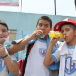 Three schoolboys drinking sugared drinks